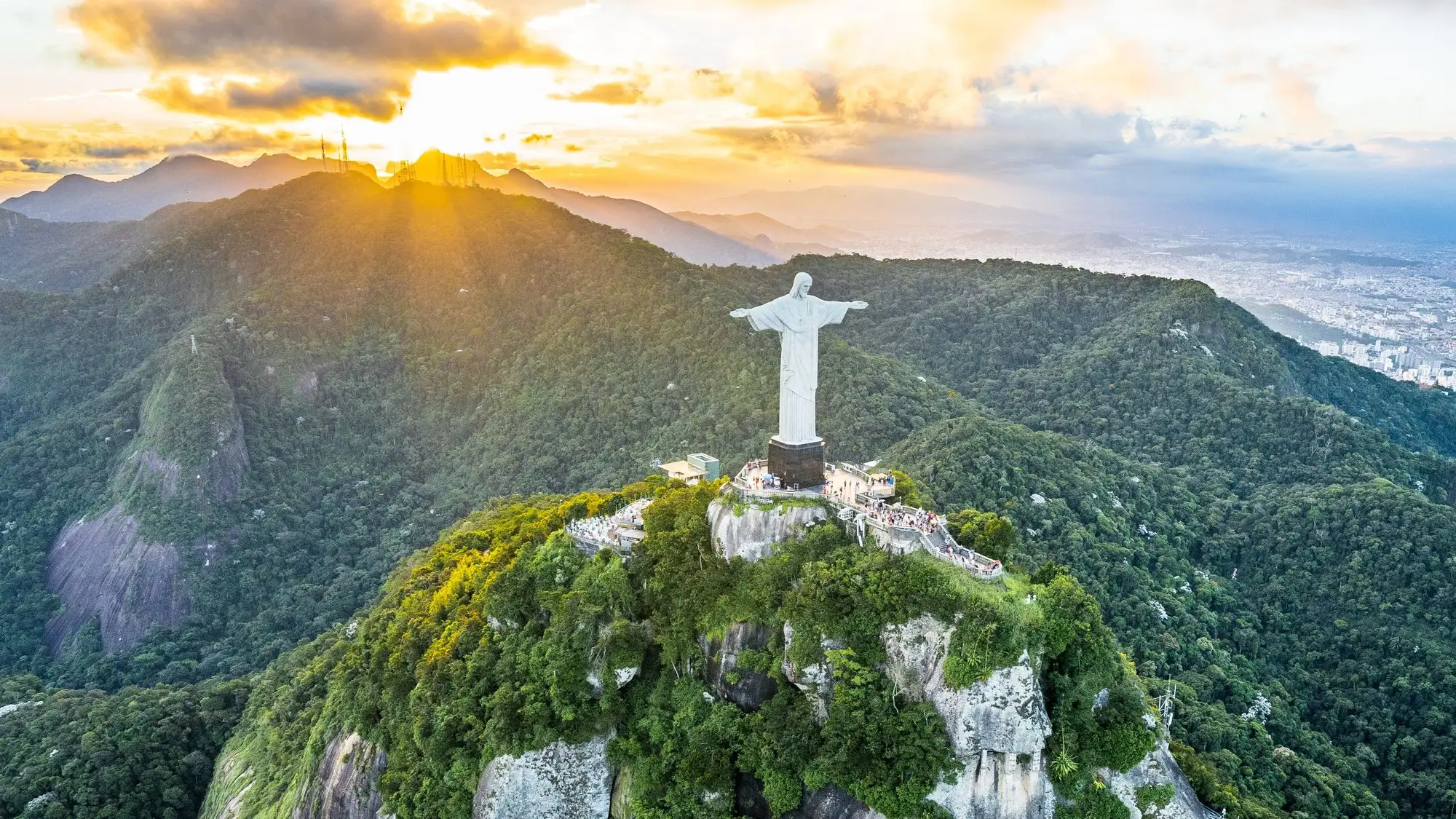 Christ the Redeemer on the summit of Corcovado at sunset, with the forested Tijuca mountains behind