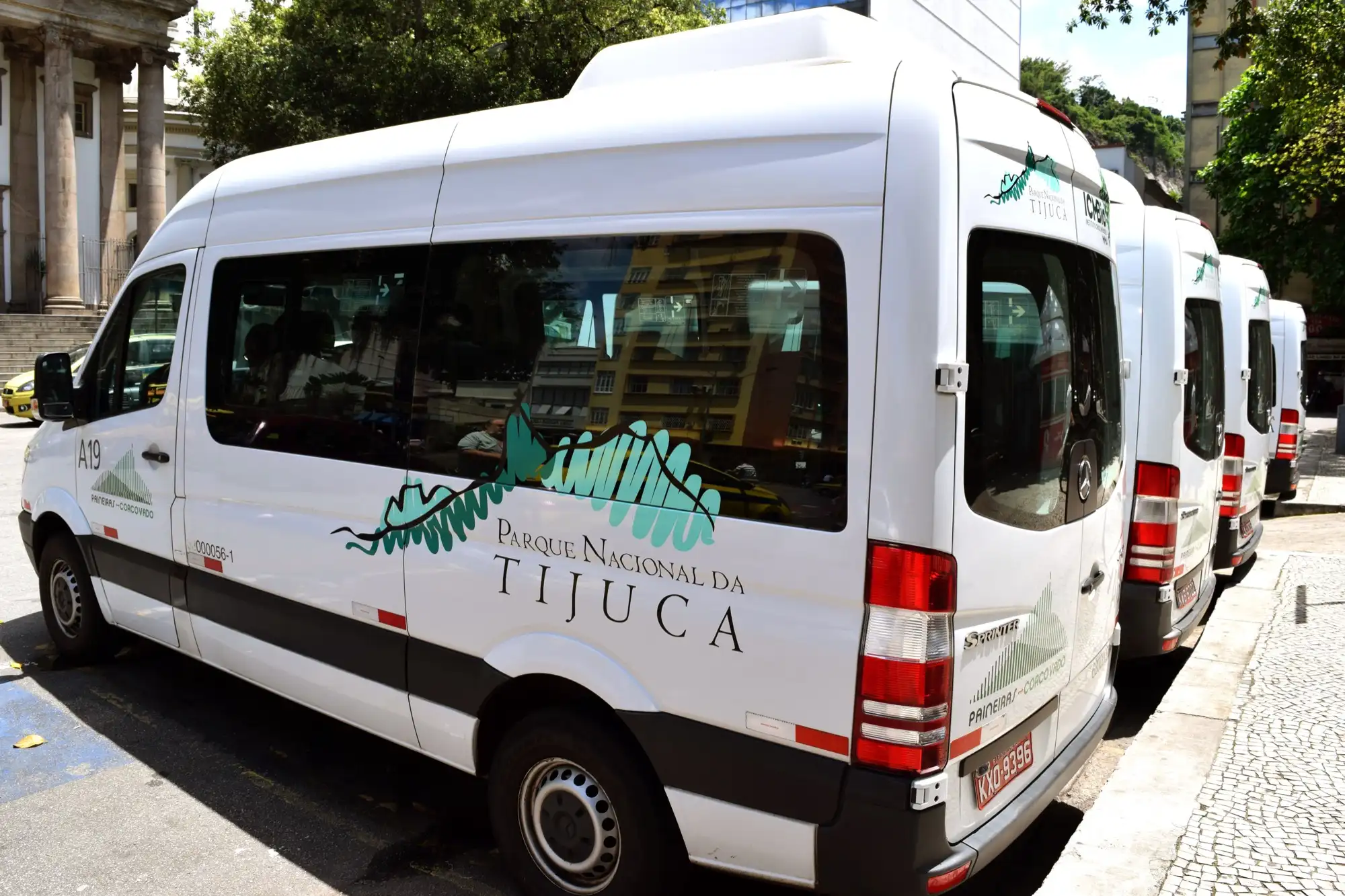 Vans oficiales de Paineiras Corcovado con los colores del Parque Nacional de Tijuca, esperando en fila en un punto de embarque de la ciudad