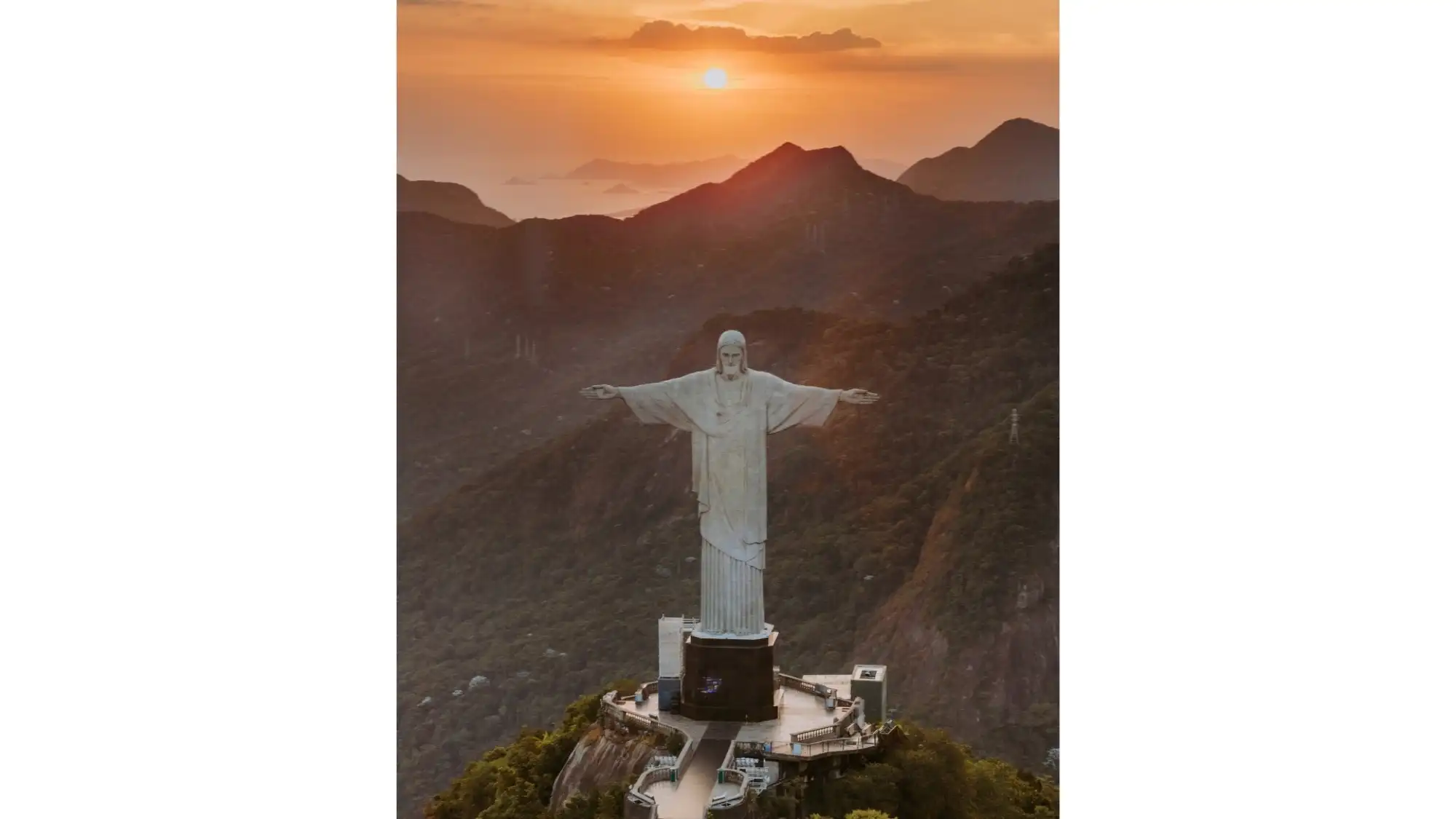 Christ the Redeemer seen from above at sunset, the pale surface of the statue catching the low light