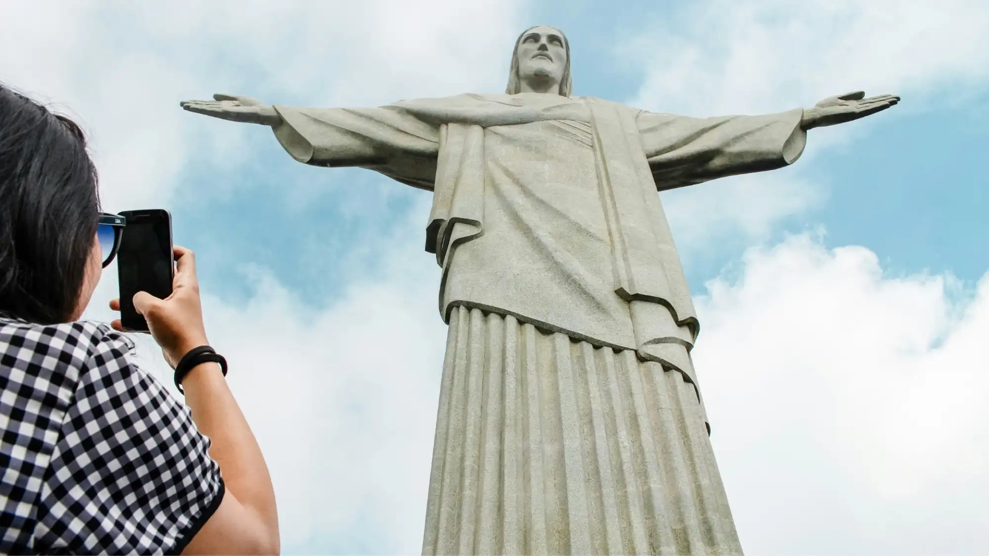 Le Christ Rédempteur vu juste en dessous, les longs plis parallèles de la tunique parcourant toute la hauteur de la figure